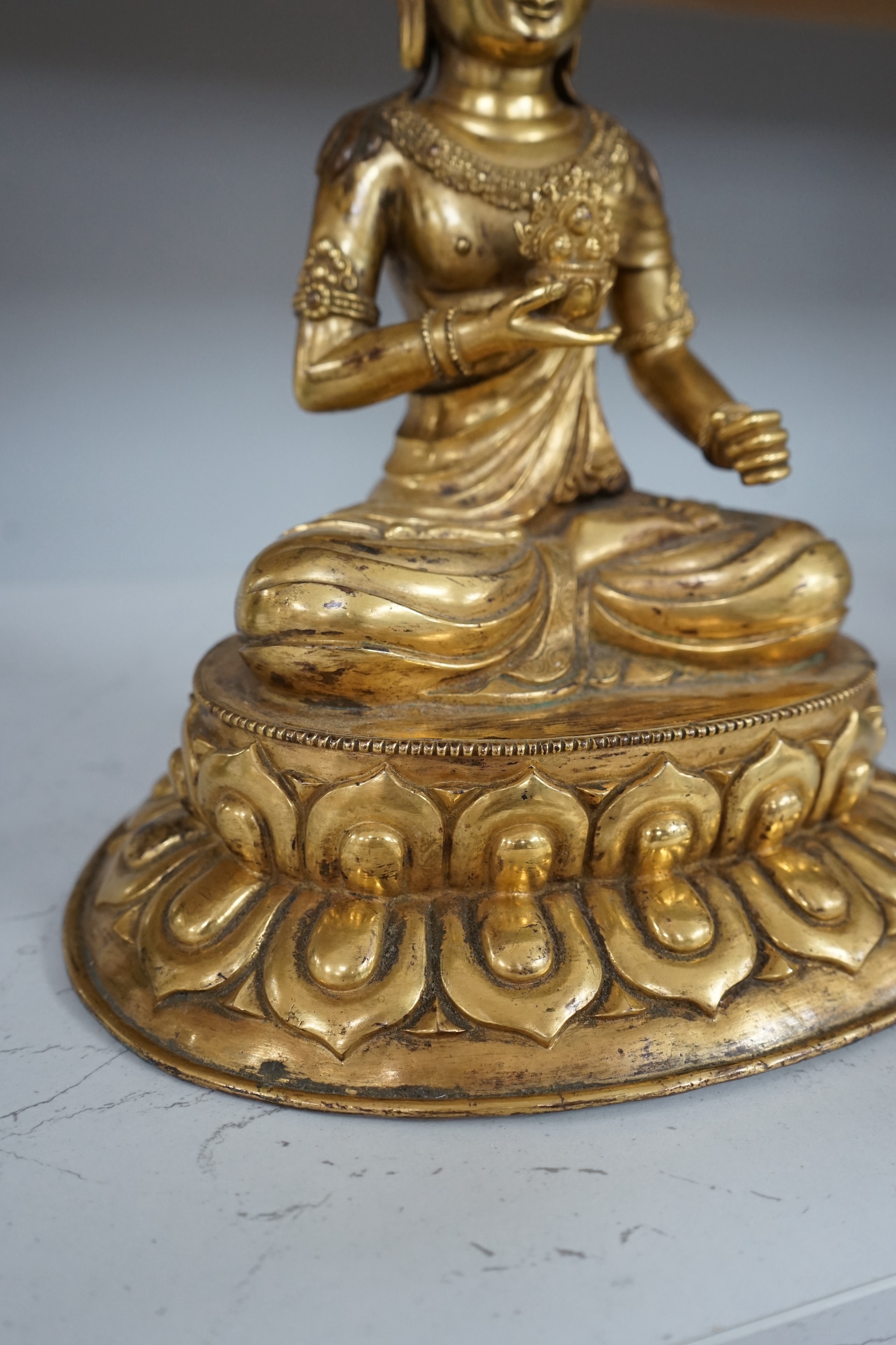 Tibetan School, 20th century gilt bronze figure of a seated deity, 31cm high. Condition - good